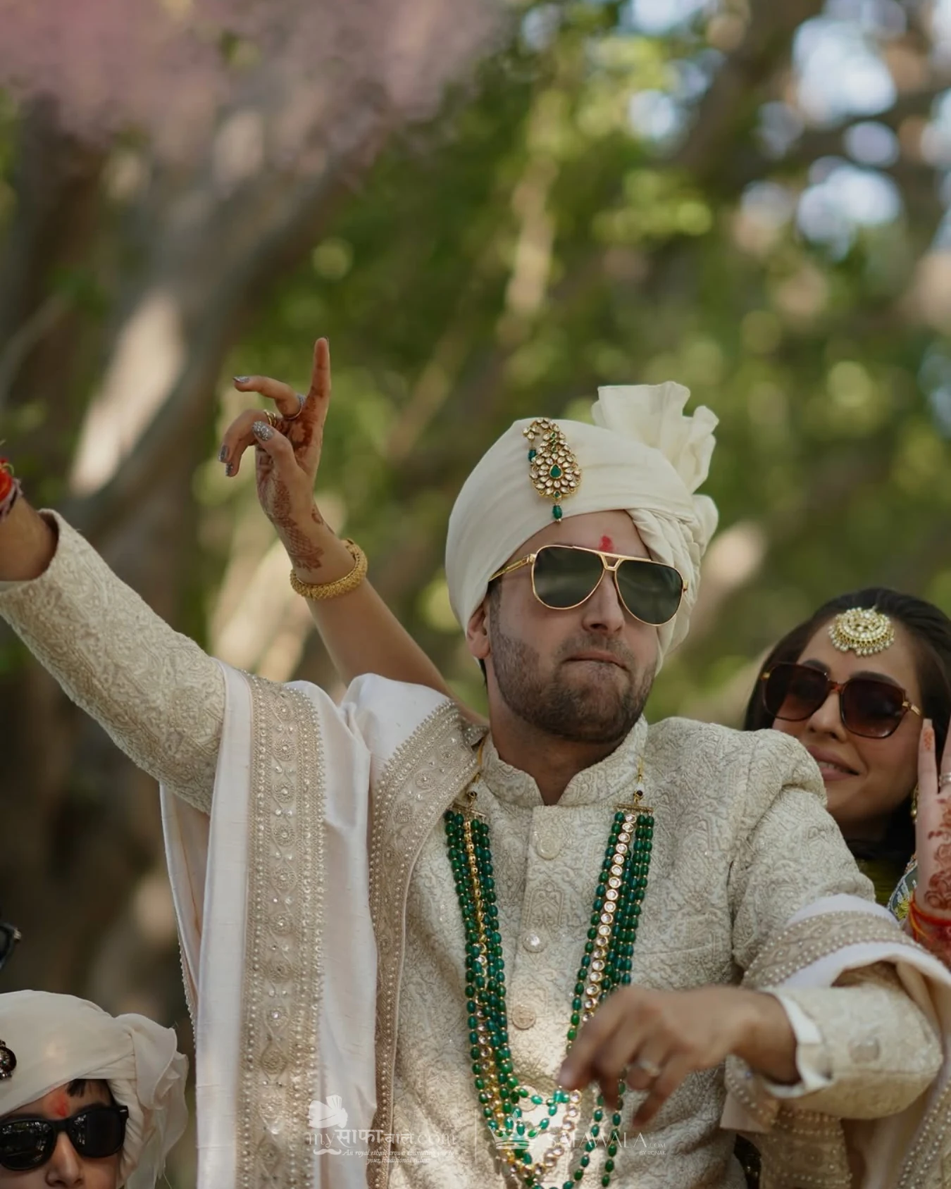 Groom in an ivory wedding safa with emerald jewellery for City Centre
